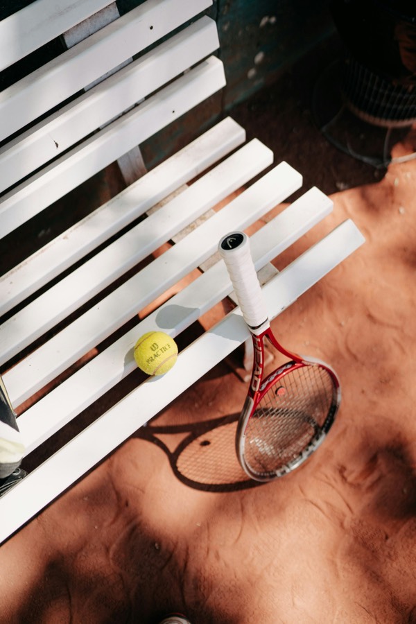 A tennis ball on a courtside bench